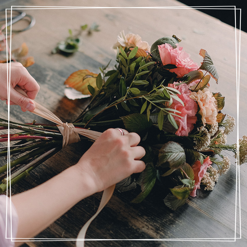 photo d'un bouquet de fleurs des champs entrain d'être préparé